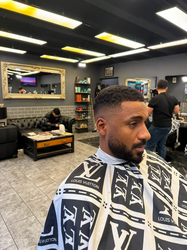A client with a sharp line-up and a full beard, the Chesterfield sofa behind him