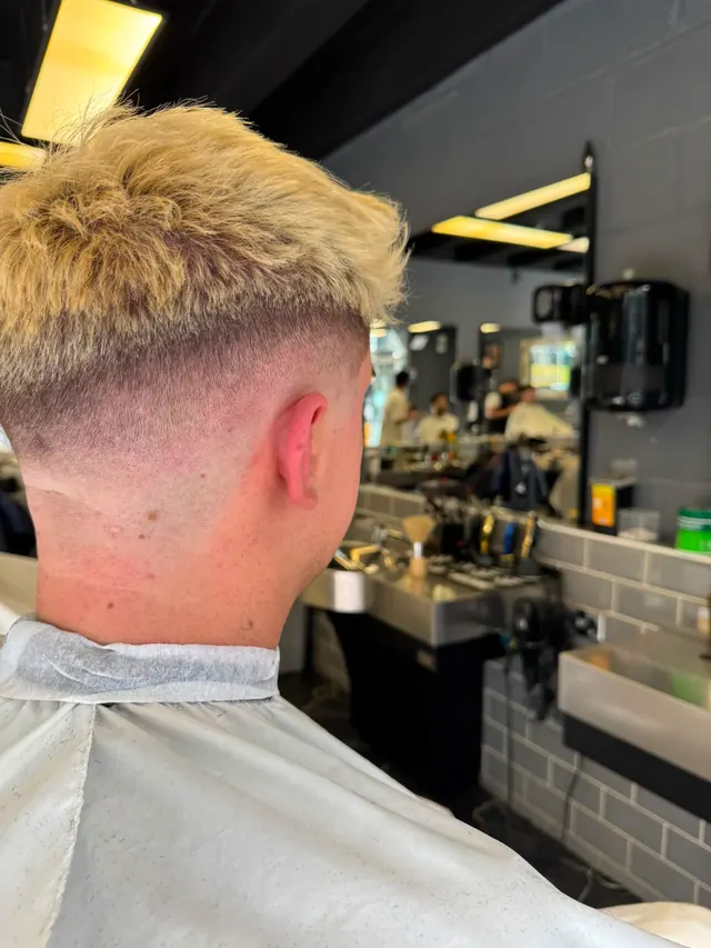 A bleached blond crop with a skin fade, from behind